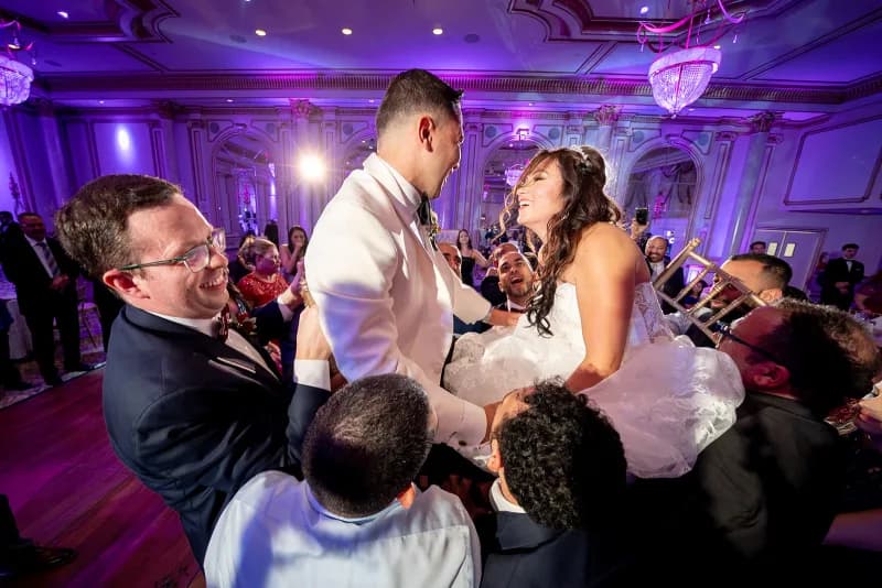 Guests celebrating around the couple on a packed dance floor