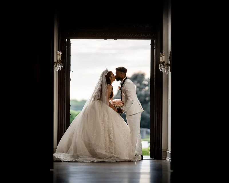 Bride and groom kissing in a dark doorway at Park Chateau